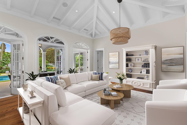 living area featuring beam ceiling, high vaulted ceiling, and wood finished floors