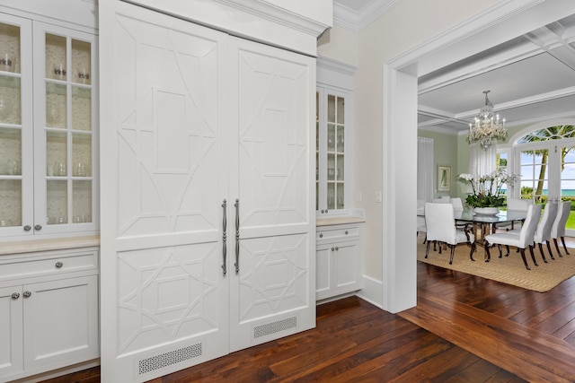 bar with white cabinets, dark hardwood / wood-style floors, crown molding, and a notable chandelier