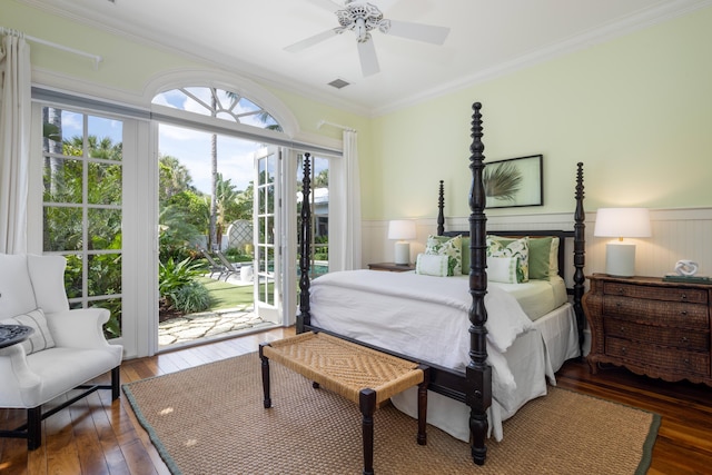 bedroom featuring access to outside, wood-type flooring, wainscoting, and crown molding