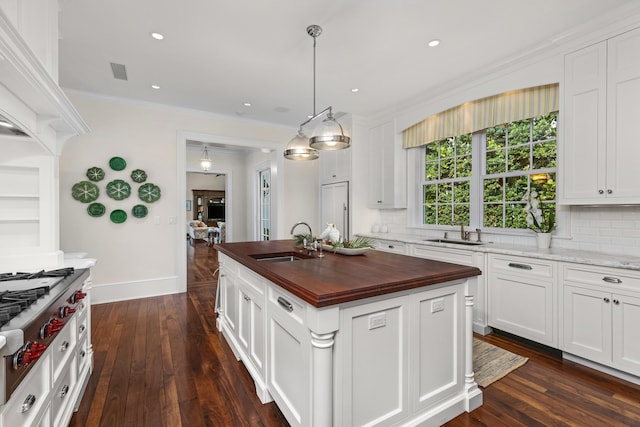 kitchen featuring dark hardwood / wood-style flooring, sink, a center island, and wood counters