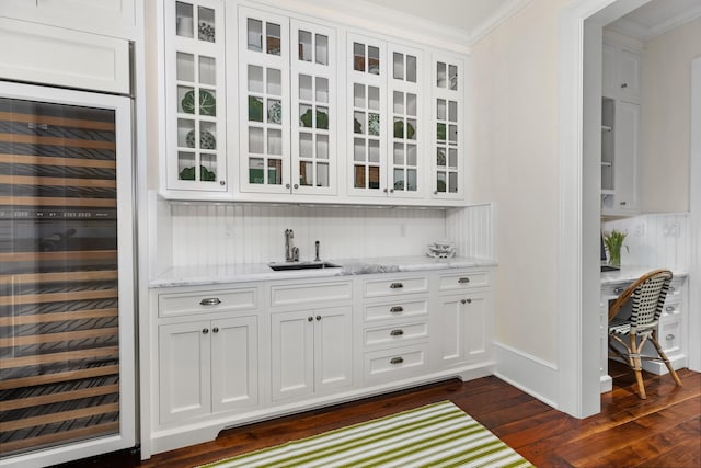 bar featuring light stone countertops, sink, beverage cooler, dark hardwood / wood-style floors, and white cabinets