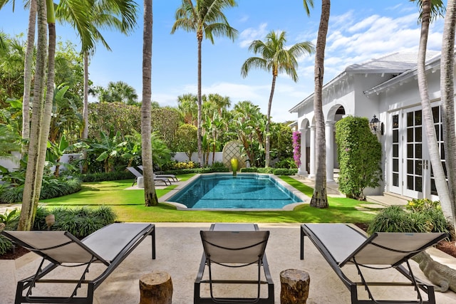 view of swimming pool featuring a lawn, french doors, and a patio