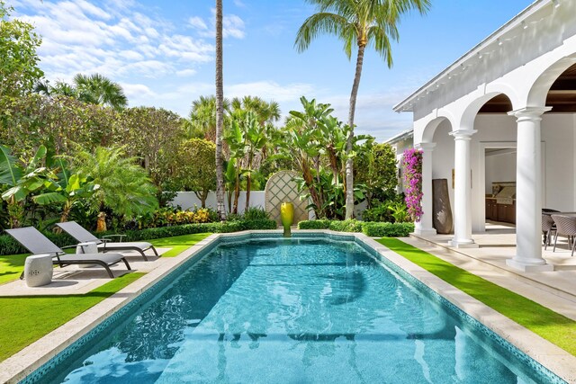 view of swimming pool featuring a yard, a fenced in pool, french doors, and a patio