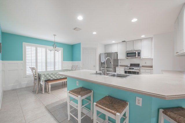 kitchen featuring pendant lighting, a breakfast bar, sink, and appliances with stainless steel finishes