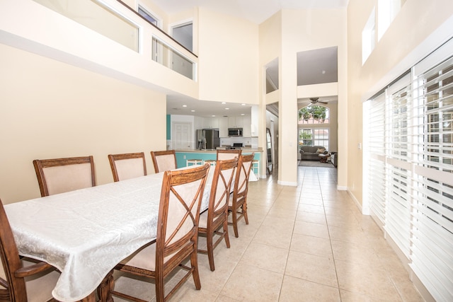 dining space with light tile patterned floors and a high ceiling