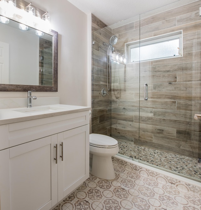 bathroom with vanity, an enclosed shower, and toilet