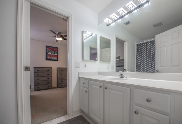 bathroom featuring curtained shower, ceiling fan, and vanity