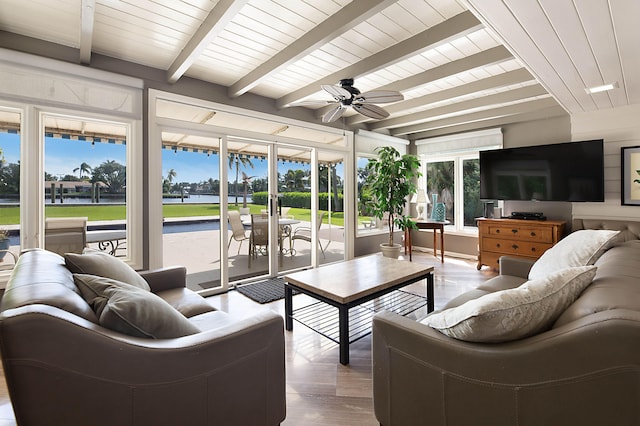 sunroom / solarium featuring ceiling fan and beamed ceiling