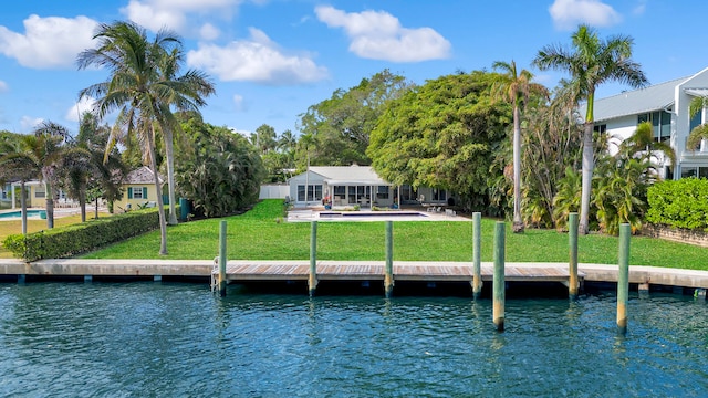 view of dock with a lawn and a water view