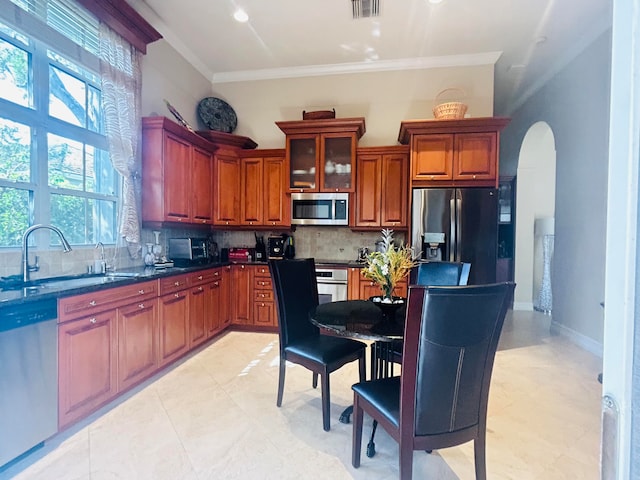 kitchen with tasteful backsplash, light tile patterned flooring, crown molding, stainless steel appliances, and sink