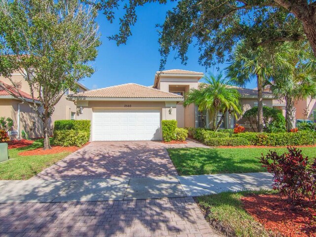 mediterranean / spanish house with a garage and a front yard