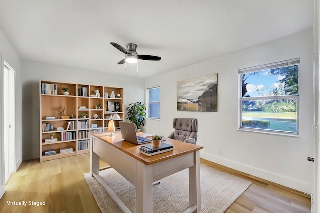 home office with plenty of natural light, ceiling fan, and light hardwood / wood-style flooring