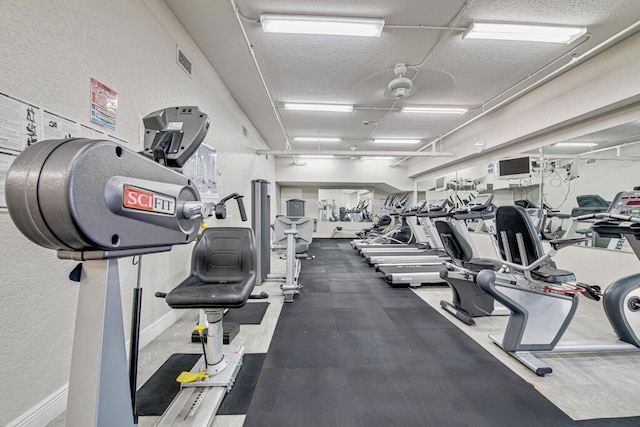 exercise room featuring a textured ceiling and ceiling fan