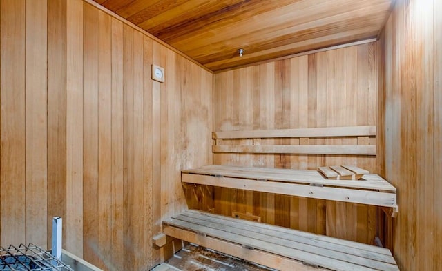 view of sauna / steam room featuring wooden ceiling and wooden walls