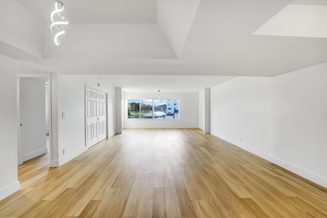 unfurnished living room with a skylight and light hardwood / wood-style flooring