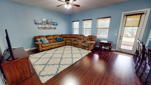 living room with dark hardwood / wood-style flooring and ceiling fan