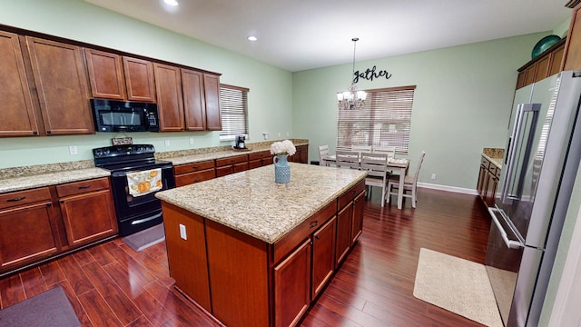 kitchen with black appliances, a kitchen island, dark wood-type flooring, and hanging light fixtures