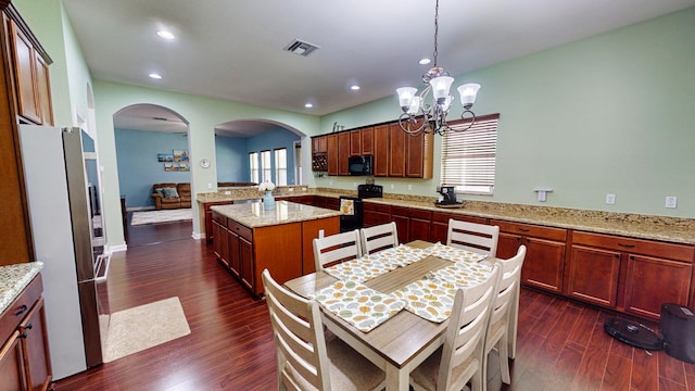 kitchen featuring black appliances, a healthy amount of sunlight, dark hardwood / wood-style floors, and a center island