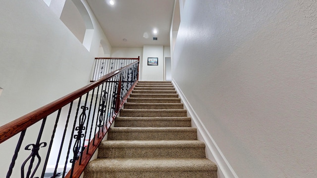 staircase featuring carpet