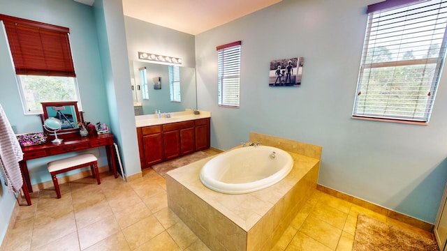 bathroom with a wealth of natural light, vanity, tiled tub, and tile patterned floors