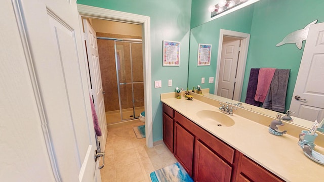 bathroom with vanity, a shower with door, tile patterned flooring, and toilet