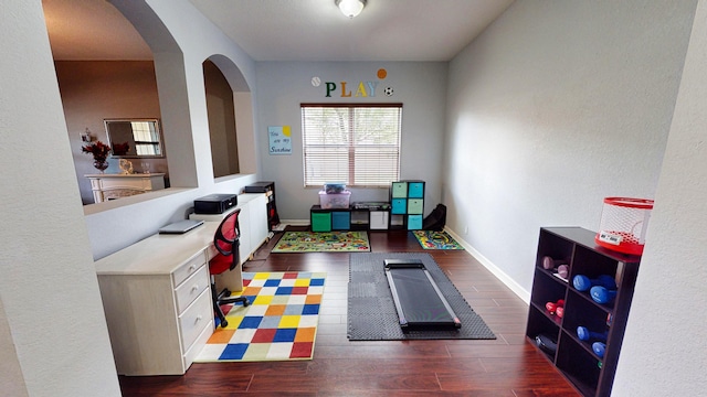 playroom featuring built in desk and dark hardwood / wood-style flooring