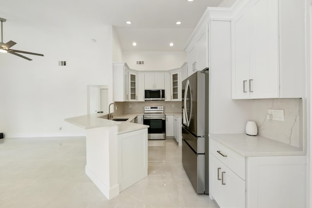 kitchen with white cabinetry, ceiling fan, high vaulted ceiling, kitchen peninsula, and decorative light fixtures