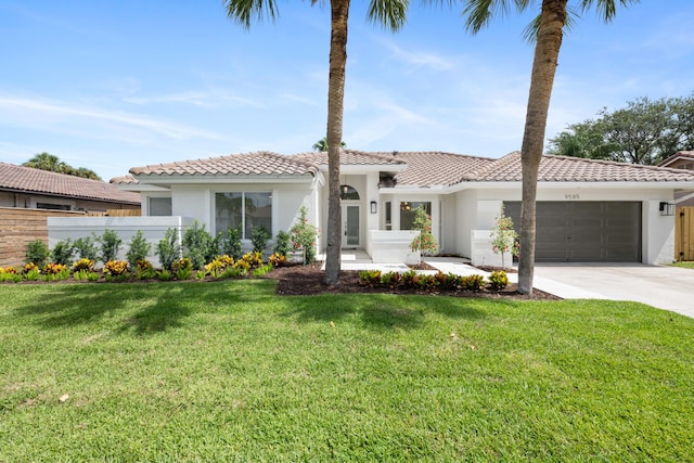 mediterranean / spanish home featuring a front yard and a garage