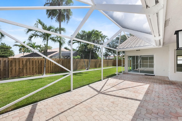 view of patio featuring ceiling fan and glass enclosure