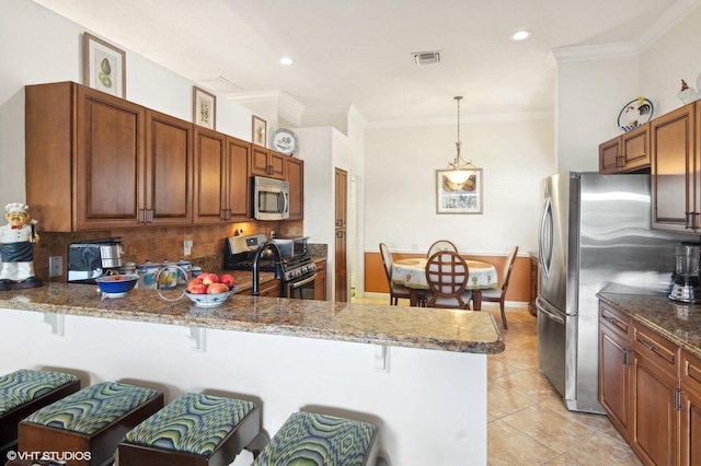 kitchen with stainless steel appliances, kitchen peninsula, pendant lighting, a breakfast bar, and light tile patterned flooring