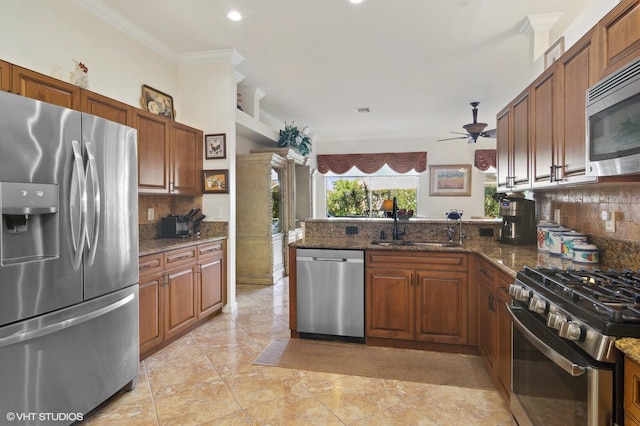 kitchen with dark stone countertops, decorative backsplash, sink, and stainless steel appliances