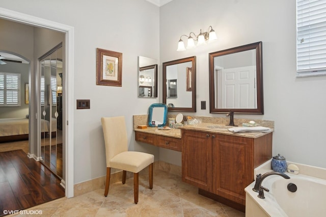 bathroom featuring tile patterned flooring, vanity, a bathtub, and ceiling fan