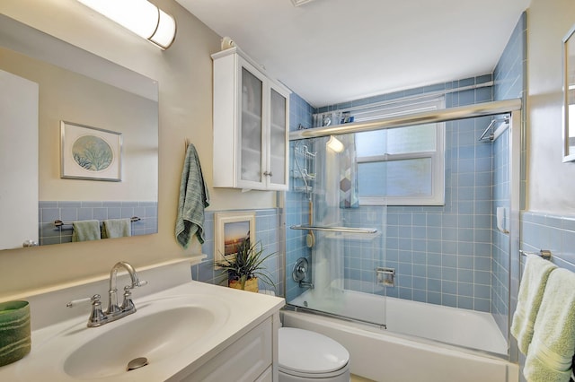 full bathroom with vanity, enclosed tub / shower combo, and toilet