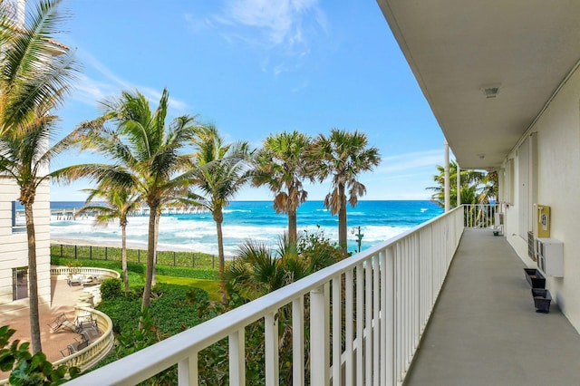 balcony featuring a water view and a view of the beach