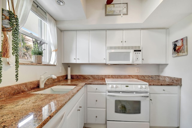 kitchen featuring light stone countertops, white appliances, white cabinetry, and sink