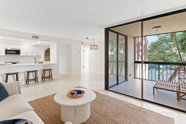 tiled living room with a wall of windows and sink