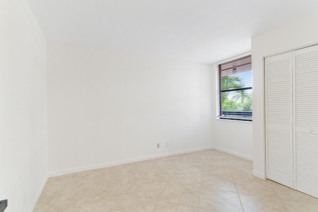 unfurnished bedroom featuring light tile patterned floors and a closet