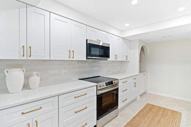 kitchen with white cabinetry, backsplash, light tile patterned floors, and stainless steel appliances