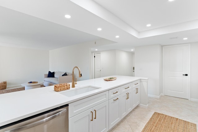 kitchen with stainless steel dishwasher, sink, light tile patterned floors, and white cabinets