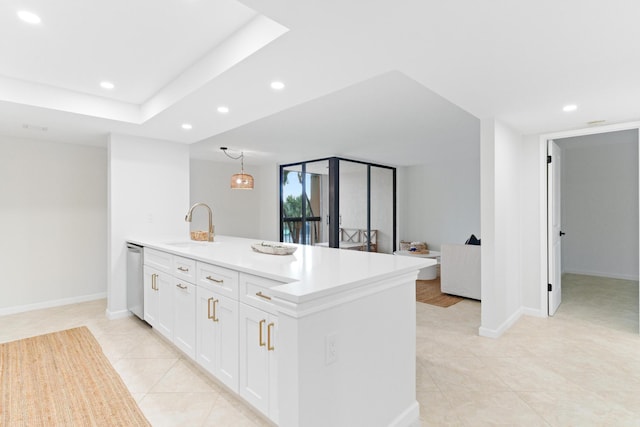 kitchen featuring white cabinets, sink, light tile patterned floors, stainless steel dishwasher, and decorative light fixtures