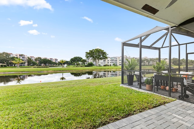 view of yard with glass enclosure and a water view