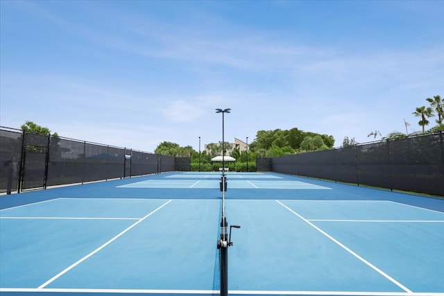 view of tennis court featuring basketball hoop