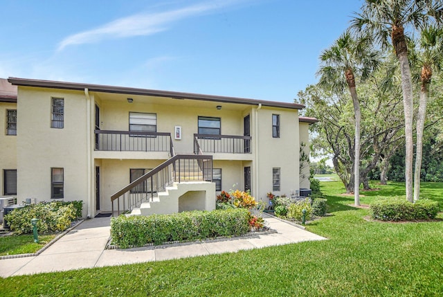 view of front of property with a balcony and a front yard