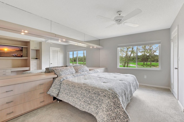 carpeted bedroom featuring ceiling fan, a textured ceiling, and a closet