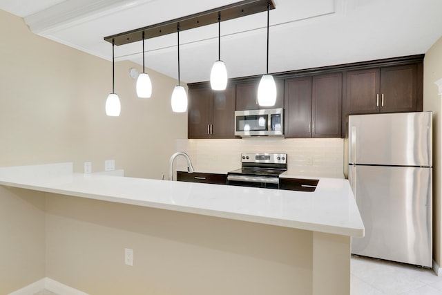 kitchen featuring stainless steel appliances, decorative light fixtures, tasteful backsplash, and dark brown cabinetry