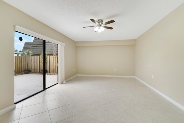 tiled spare room with ceiling fan