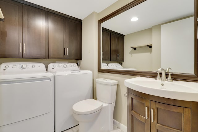 bathroom with toilet, vanity, and separate washer and dryer