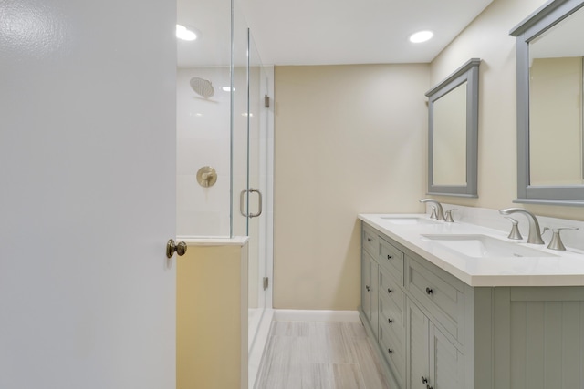 bathroom featuring a shower with door and vanity