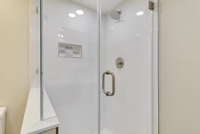 bathroom with an enclosed shower and toilet