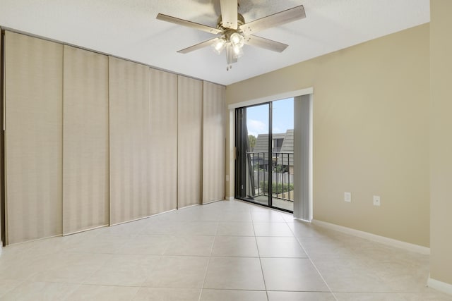 tiled empty room featuring ceiling fan